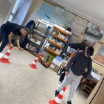 Dva dijaka pripravljata poligon s stožci za spretnostno vožnjo z e-skirojem.