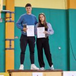 Naj atlet in naj atletinja šole na zmagovalnem odru s priznanjema v roki.