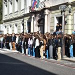Dijaki stojijo na ulici in pojejo Slovansko pesem.