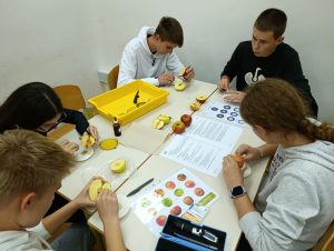 Dijaki izvajajo eksperimente pri delavnici Ugriznimo v jabolko.