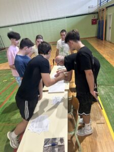 Dijaki s profesorjem pri zapisnikarski mizi