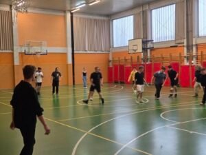 Dijaki uživajo v šolski telovadnici pri igranju nogometa.