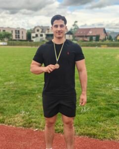 Dijak na stadionu z osvojeno medaljo.